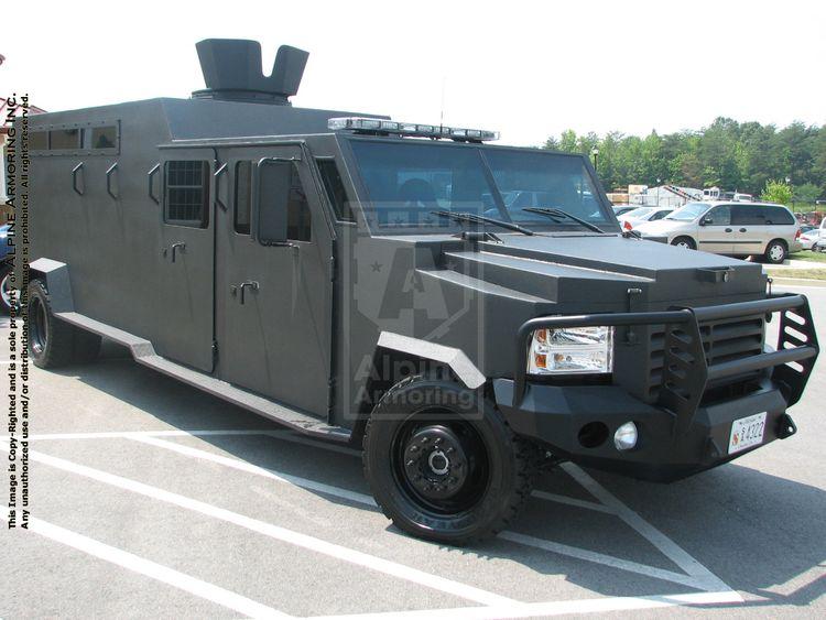 rge, black armored Boxer APC SWAT vehicle with a rugged exterior and tinted windows is parked on outdoor pavement.